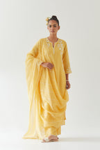 Yellow silk chanderi straight kurta set highlighted with off white thread embroidery.