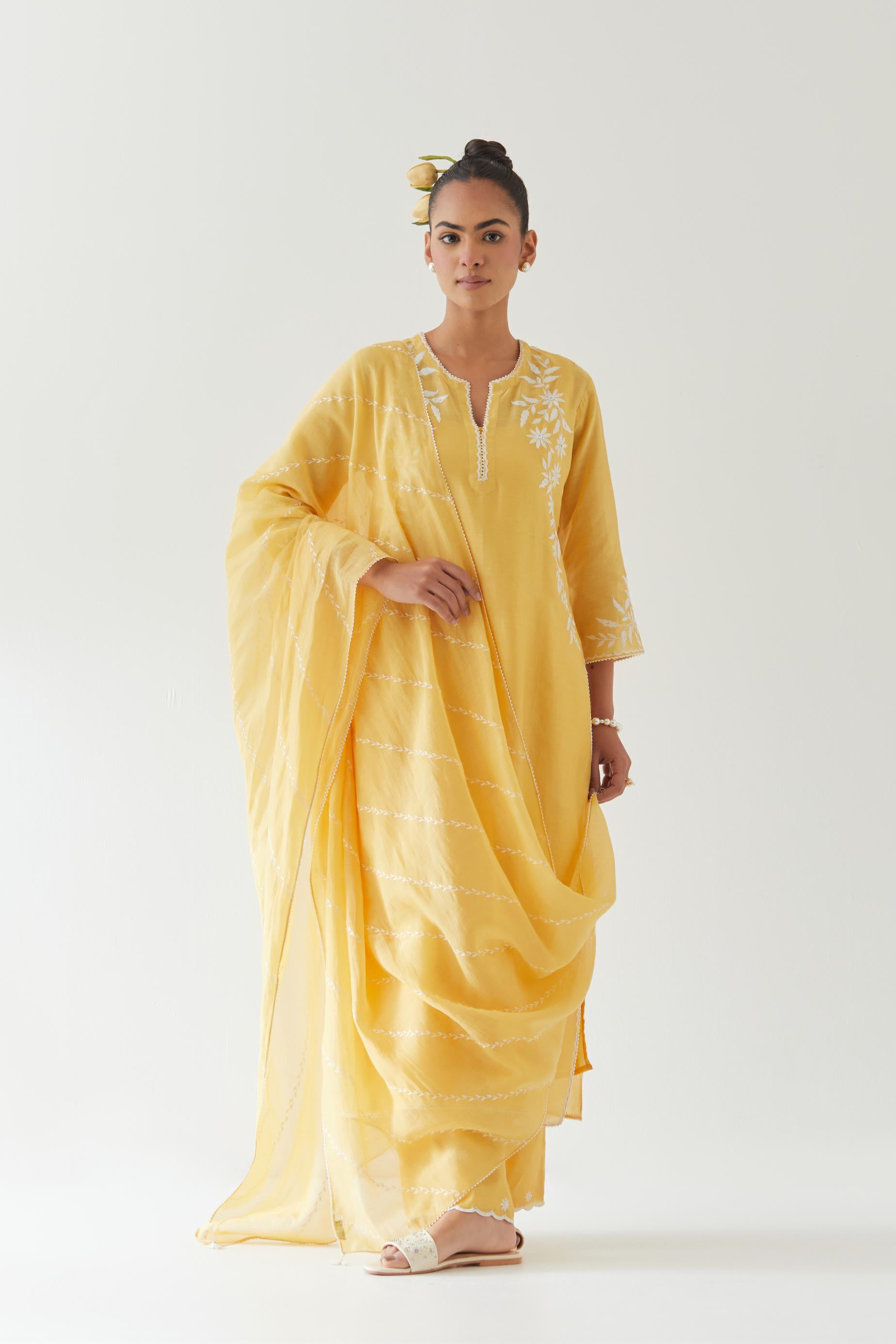 Yellow silk chanderi straight kurta set highlighted with off white thread embroidery.