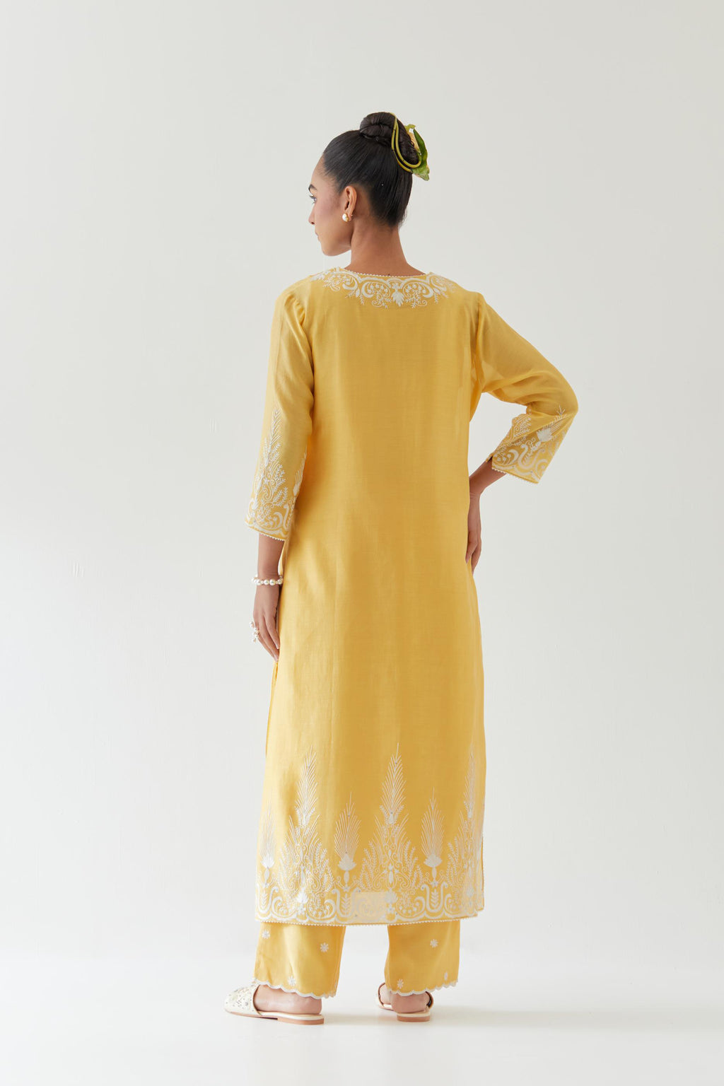 Yellow silk chanderi straight kurta set highlighted with off white thread embroidery.