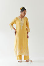 Yellow silk chanderi straight kurta set highlighted with off white thread embroidery.