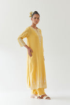 Yellow silk chanderi straight kurta set highlighted with off white thread embroidery.