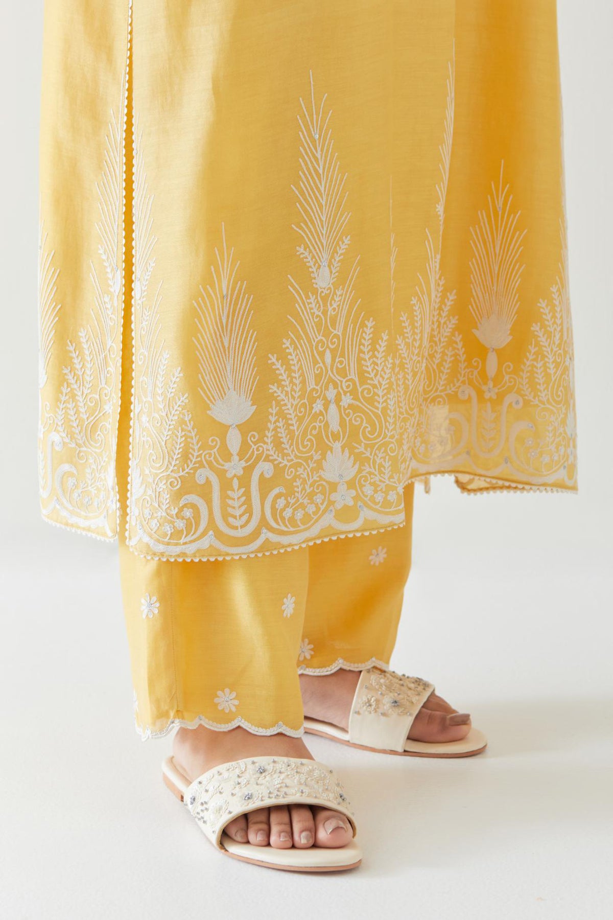 Yellow silk chanderi straight kurta set highlighted with off white thread embroidery.