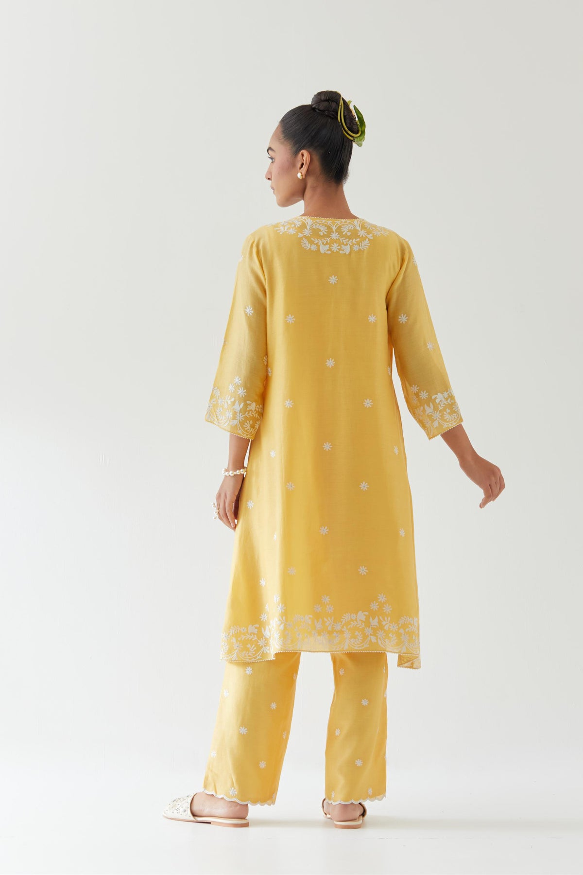 Yellow silk chanderi short A-line kurta set highlighted with off white thread embroidery.
