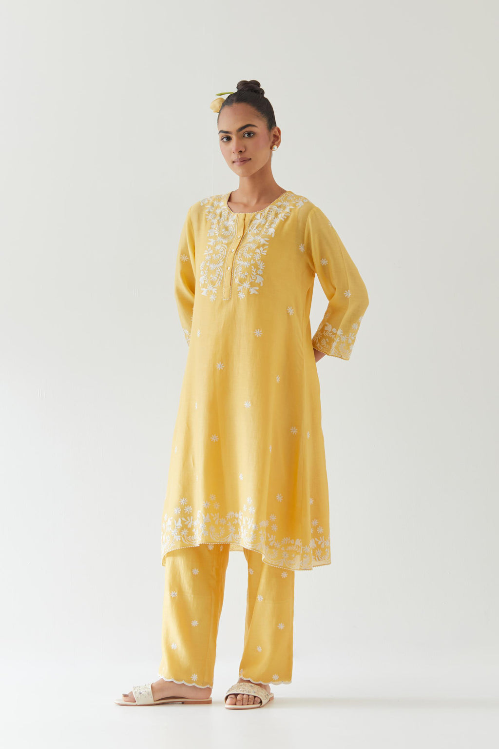 Yellow silk chanderi short A-line kurta set highlighted with off white thread embroidery.