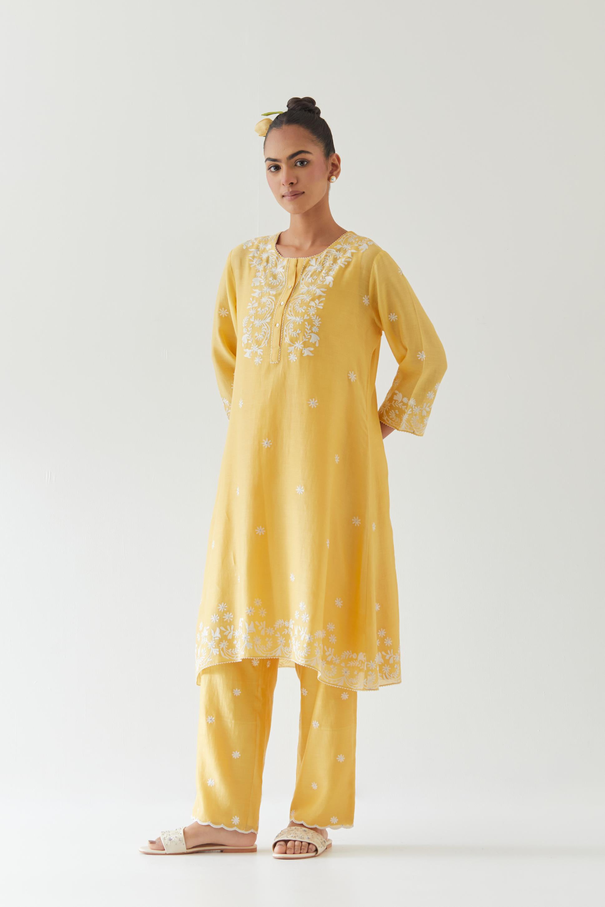 Yellow silk chanderi short A-line kurta set highlighted with off white thread embroidery.