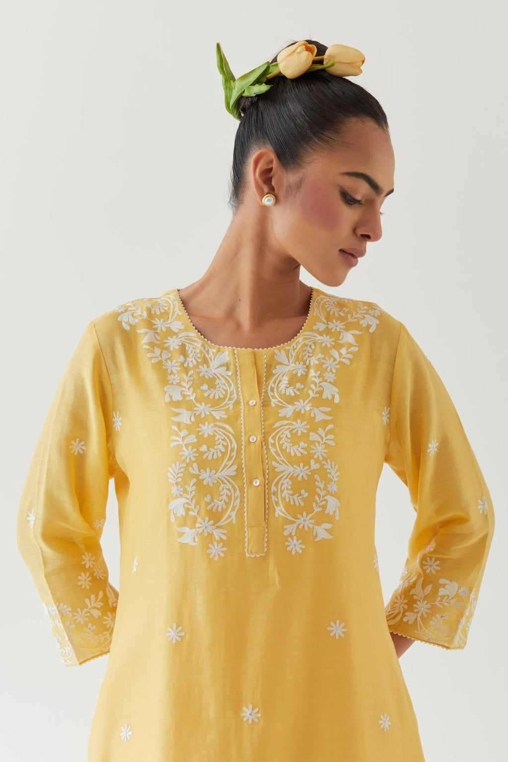 Yellow silk chanderi short A-line kurta set highlighted with off white thread embroidery.