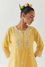Yellow silk chanderi short A-line kurta set highlighted with off white thread embroidery.