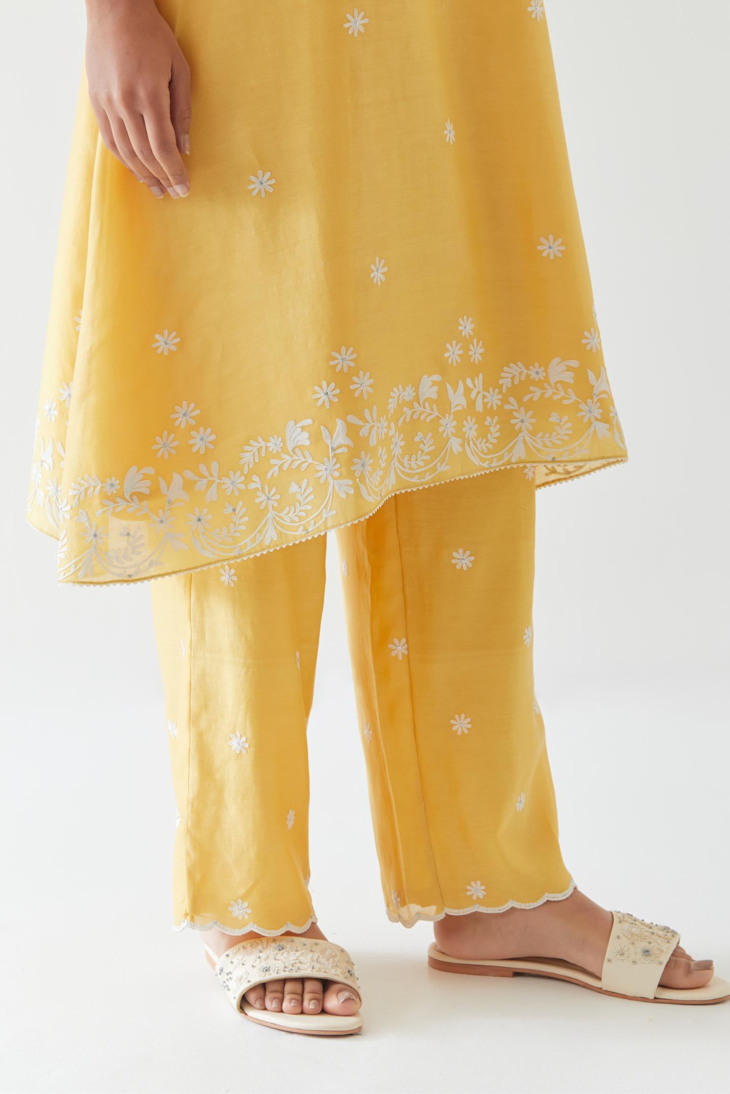 Yellow silk chanderi short A-line kurta set highlighted with off white thread embroidery.
