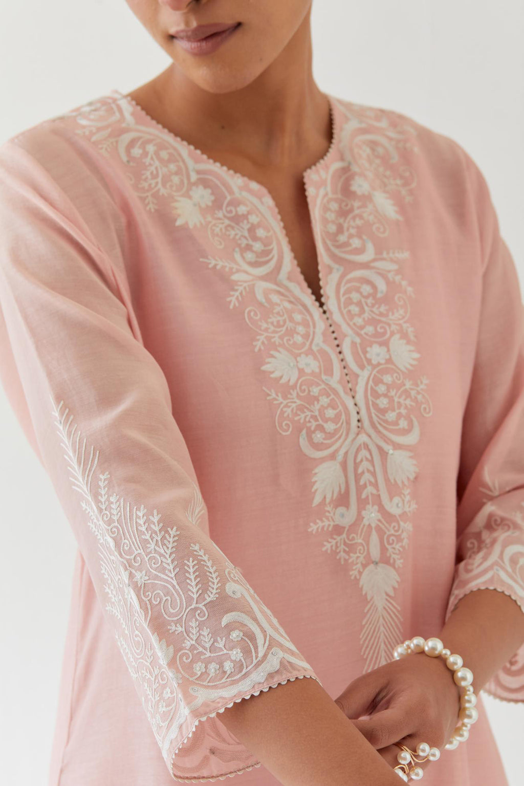 Pink silk chanderi straight kurta set highlighted with off white thread embroidery.