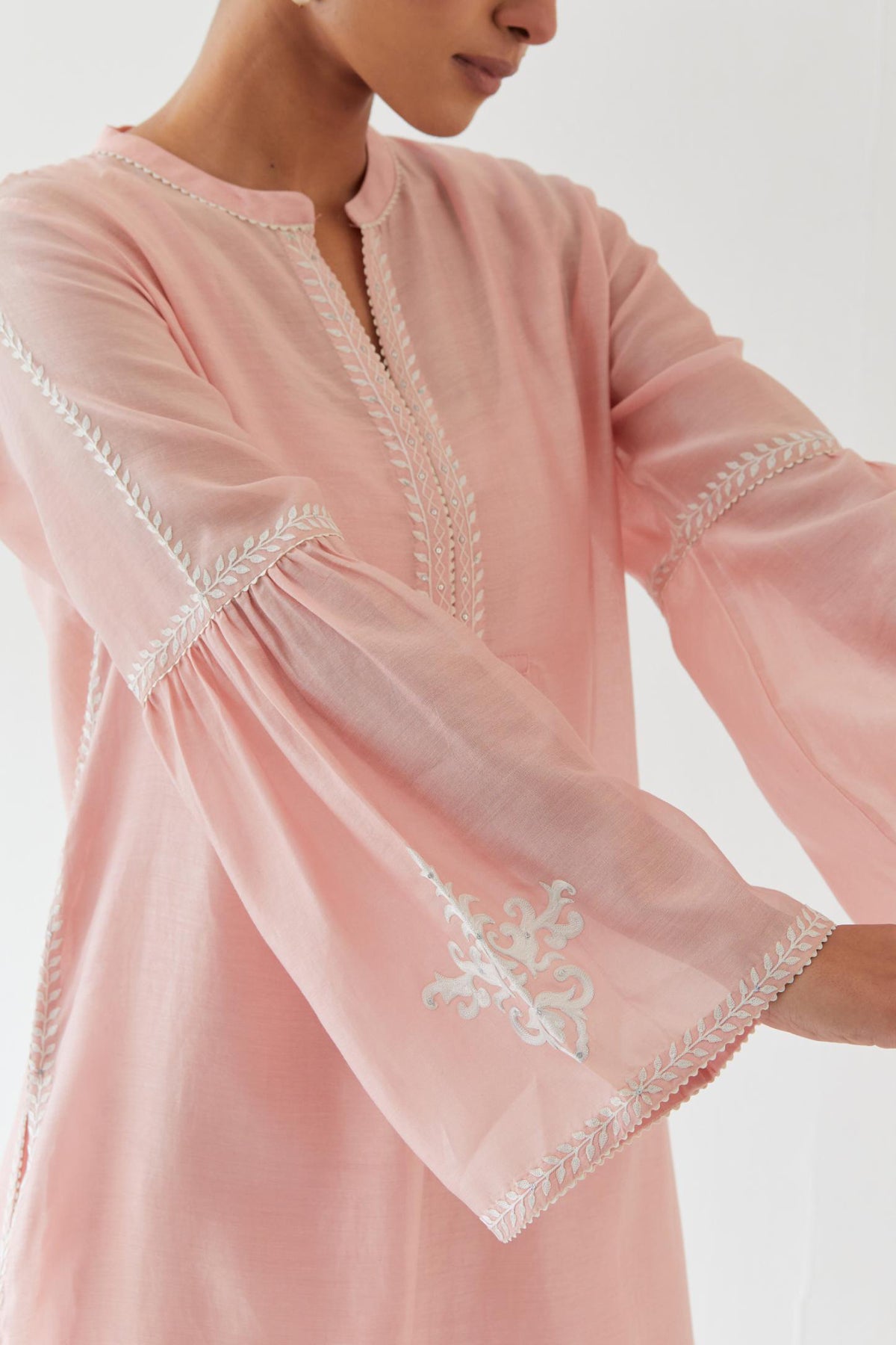 Pink silk chanderi straight kurta set with long bell sleeves, highlighted with off white thread embroidery.