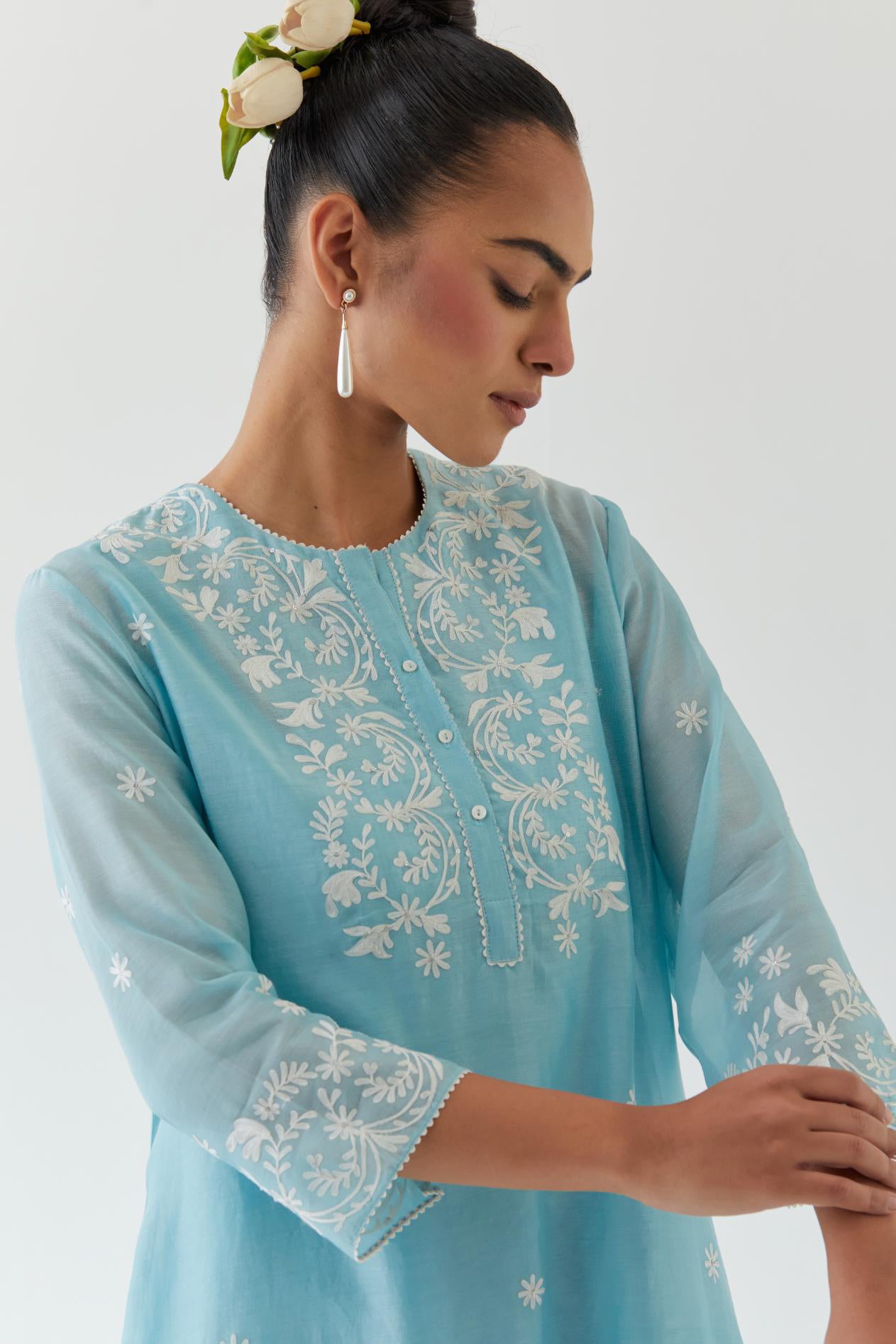 Blue silk chanderi short A-line kurta set highlighted with off white thread embroidery.