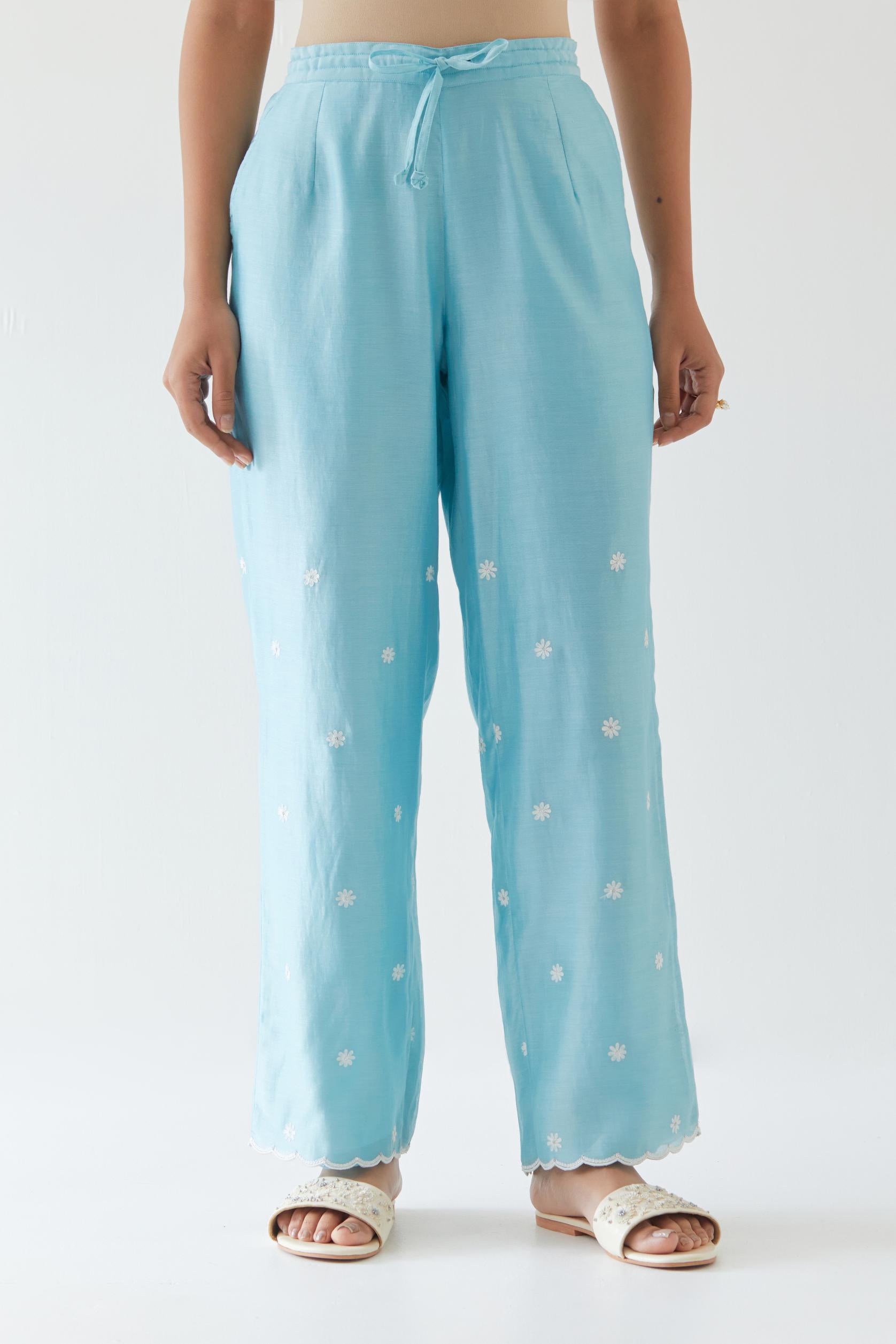 Blue silk chanderi straight pants with off white thread embroidery and scalloped edges at hem.