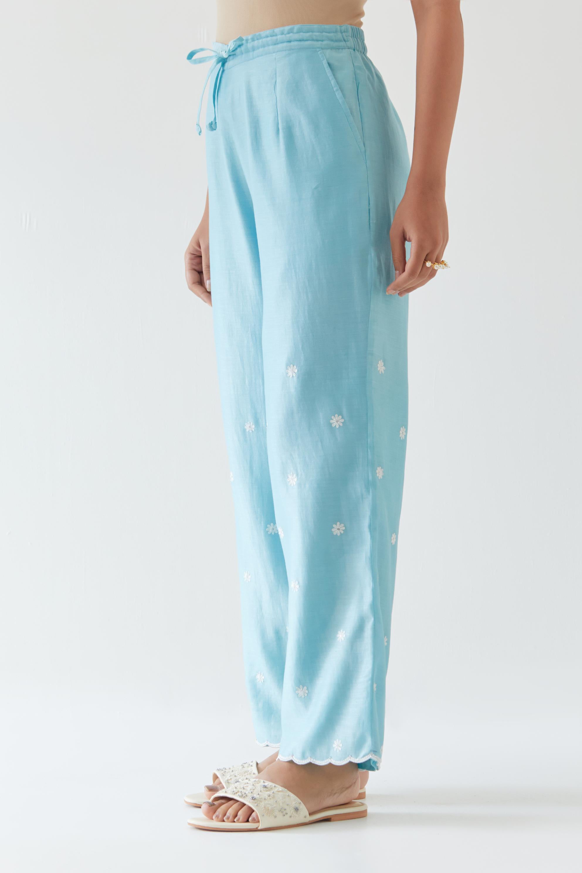 Blue silk chanderi straight pants with off white thread embroidery and scalloped edges at hem.