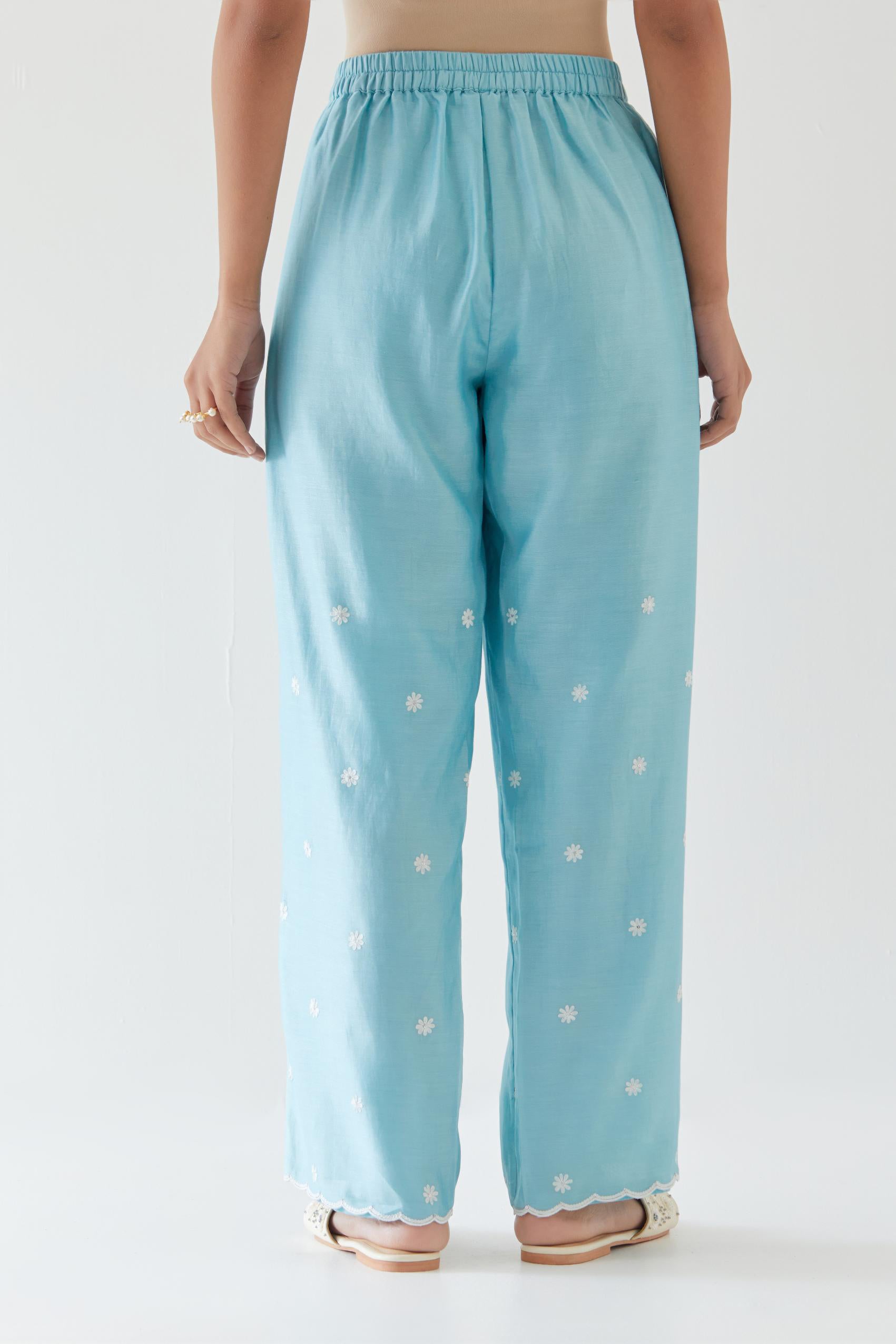 Blue silk chanderi straight pants with off white thread embroidery and scalloped edges at hem.