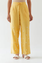 Yellow silk chanderi straight pants with off white thread embroidery and scalloped edges at hem.