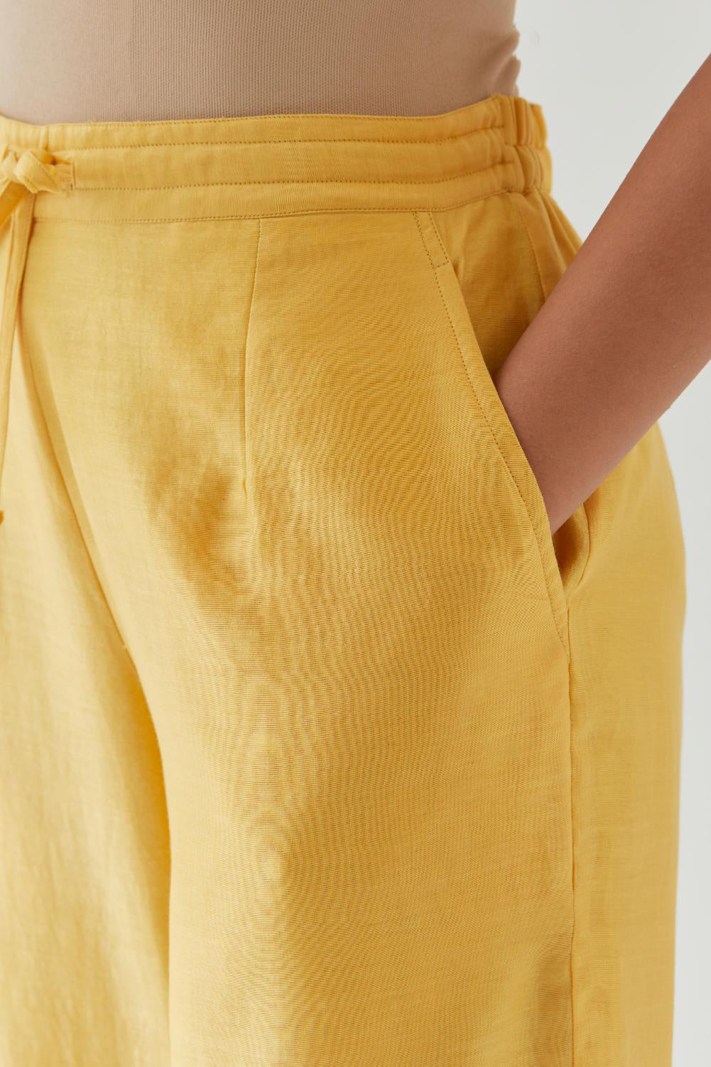Yellow silk chanderi straight pants with off white thread embroidery and scalloped edges at hem.