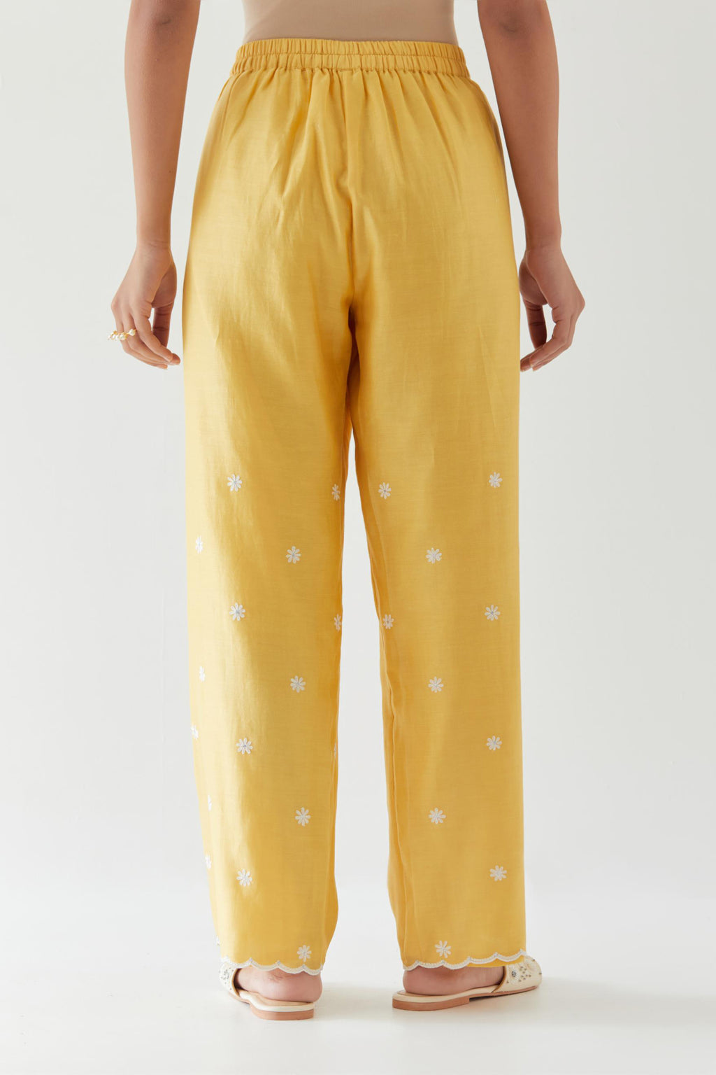 Yellow silk chanderi straight pants with off white thread embroidery and scalloped edges at hem.
