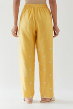 Yellow silk chanderi straight pants with off white thread embroidery and scalloped edges at hem.
