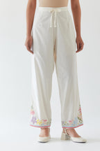 Off white cotton straight pants detailed with multi colored applique, highlighted with bead & sequins work.