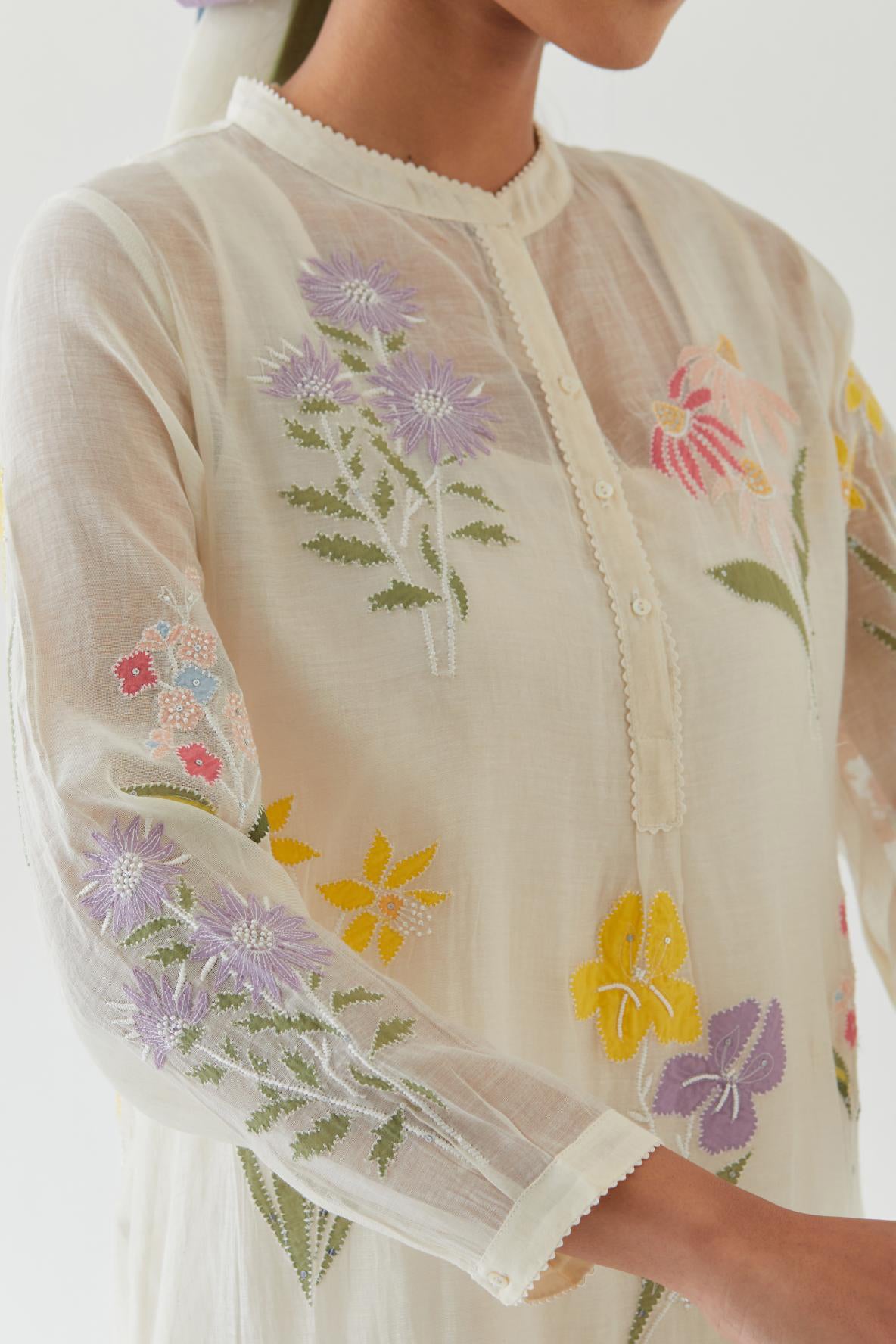 Off white cotton chanderi straight short easy fit kurta set with all-over multi colored assorted flower applique, highlighted with bead & sequins work.