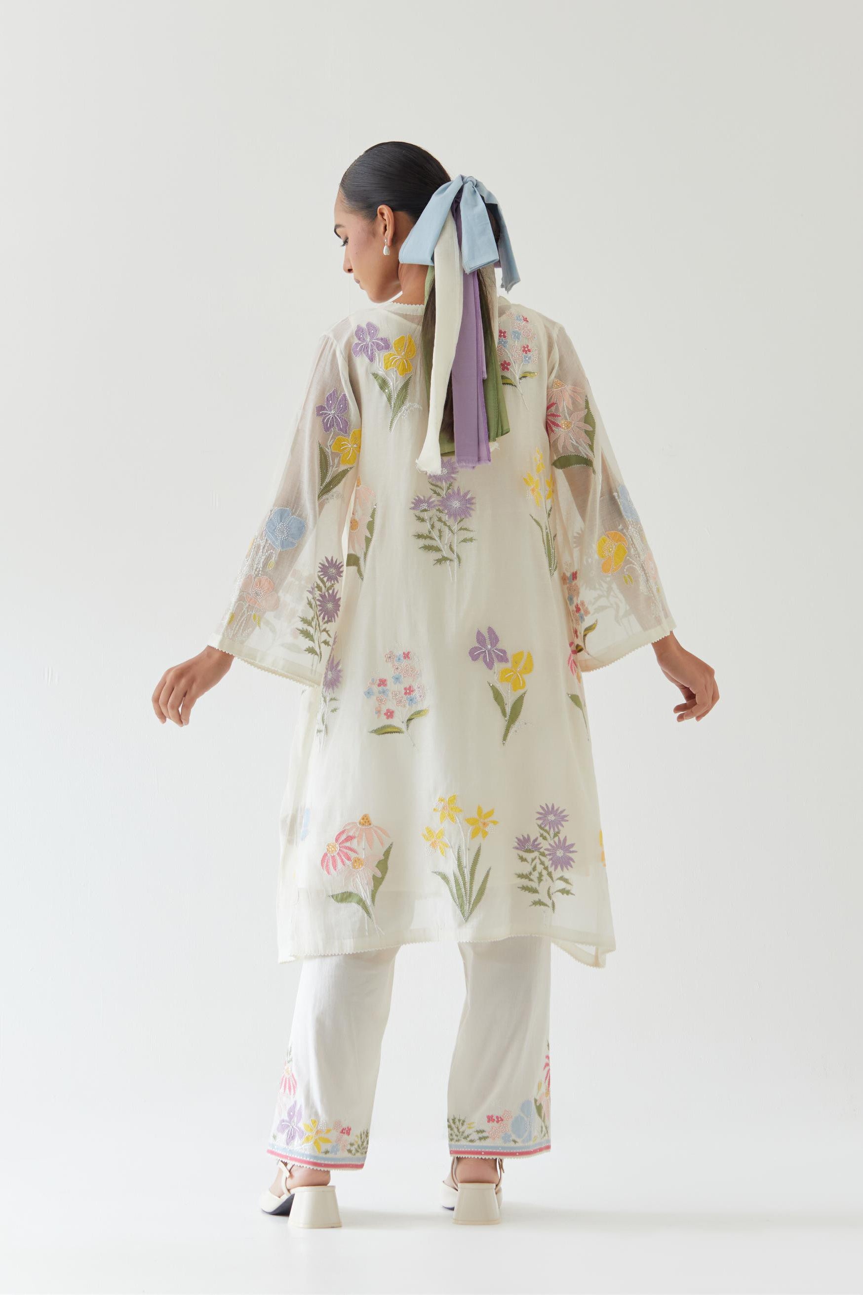 Off white cotton chanderi A-line kurta set features an all-over multi-colored assorted flower applique, highlighted with bead and sequins work.