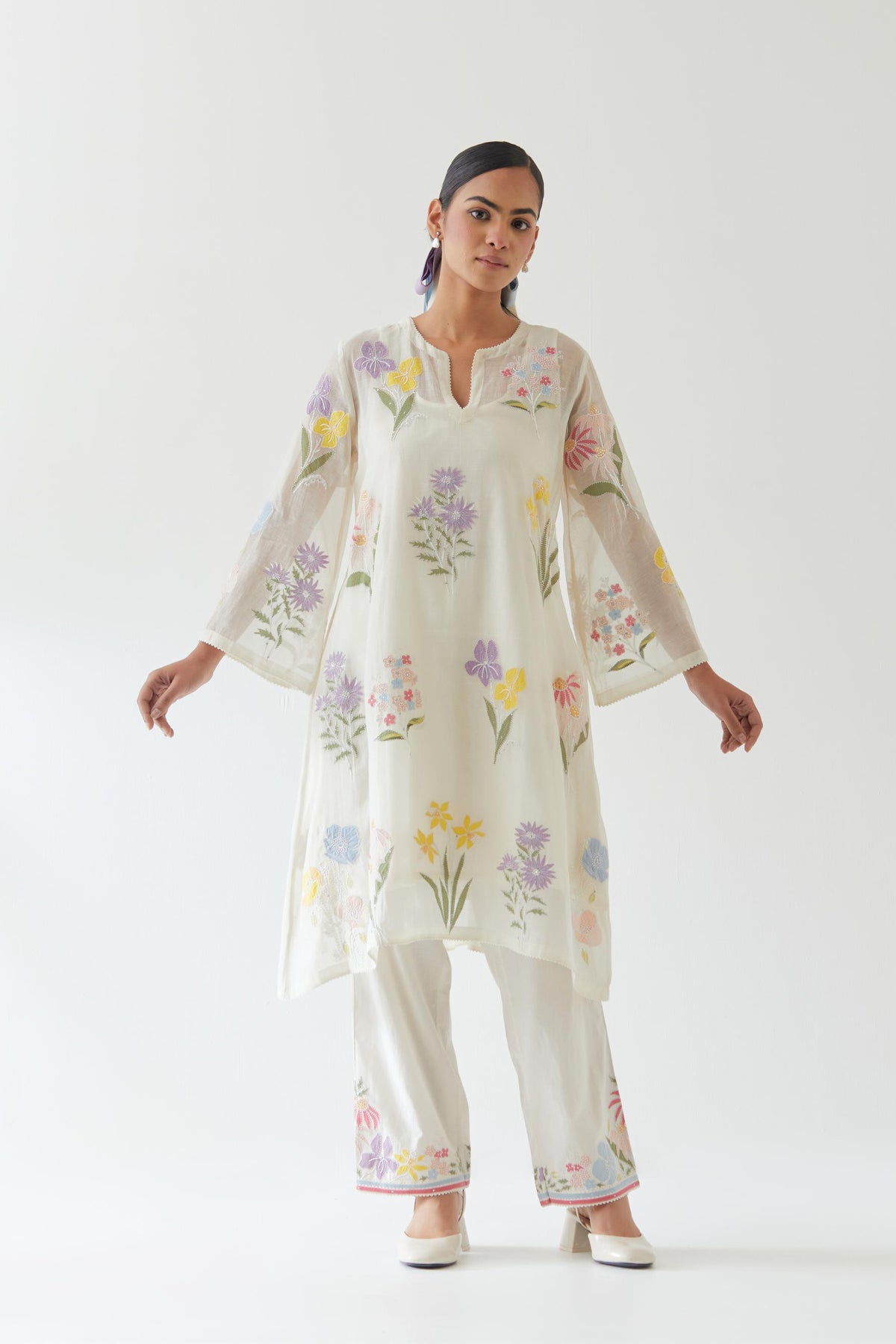 Off white cotton chanderi A-line kurta set features an all-over multi-colored assorted flower applique, highlighted with bead and sequins work.