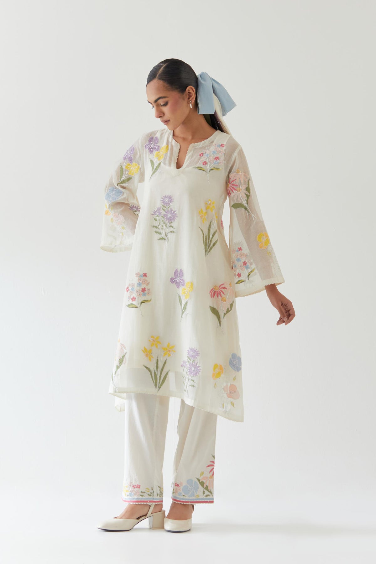 Off white cotton chanderi A-line kurta set features an all-over multi-colored assorted flower applique, highlighted with bead and sequins work.