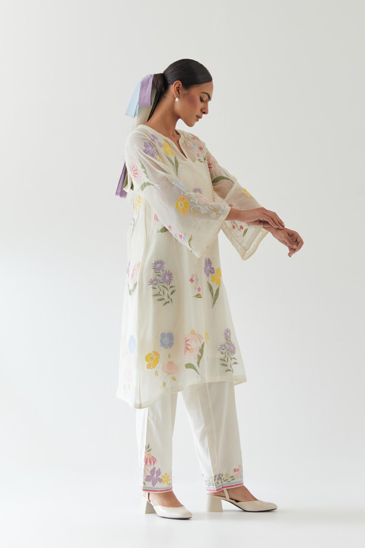 Off white cotton chanderi A-line kurta set features an all-over multi-colored assorted flower applique, highlighted with bead and sequins work.