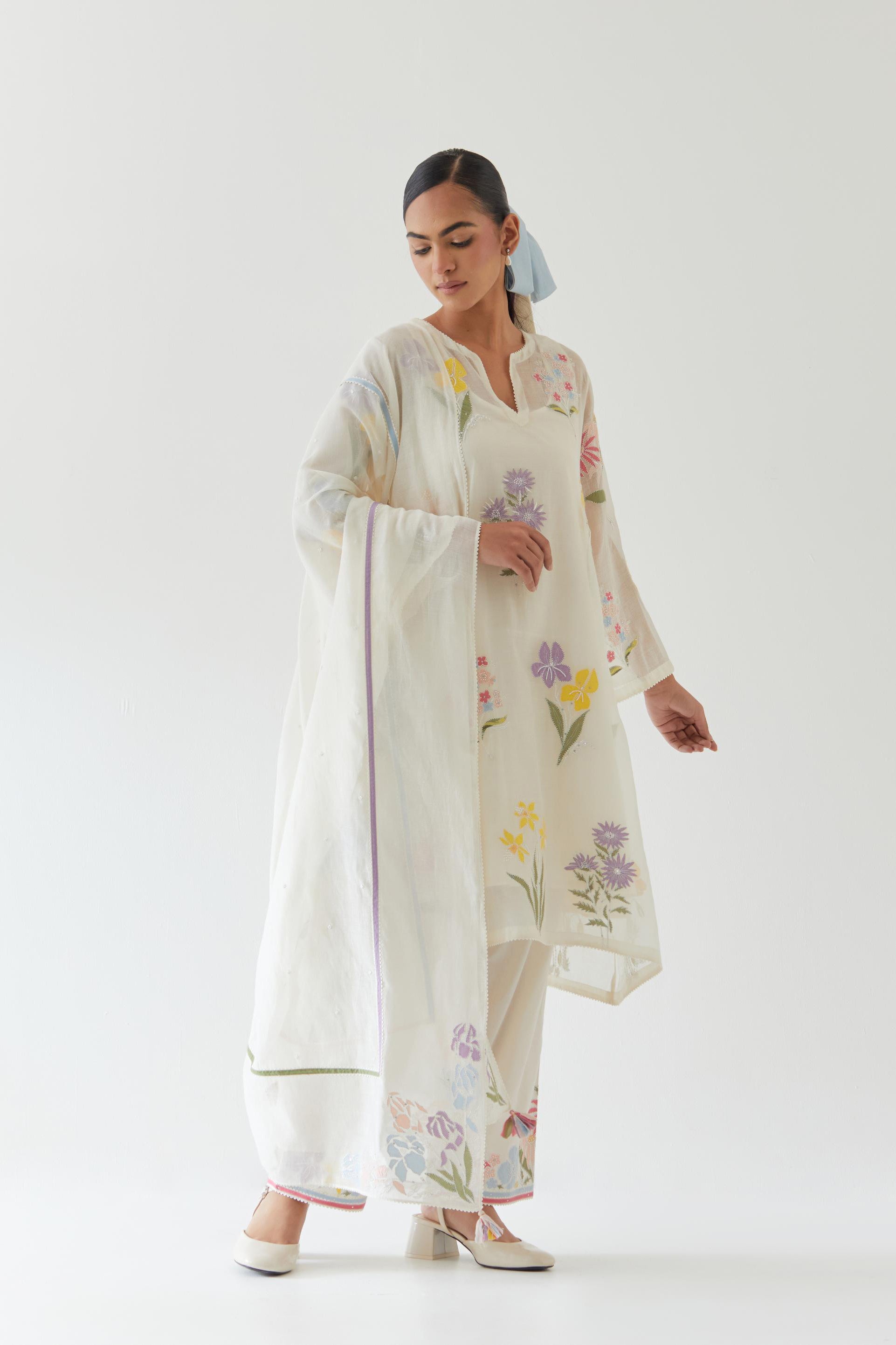 Off white cotton chanderi A-line kurta set features an all-over multi-colored assorted flower applique, highlighted with bead and sequins work.