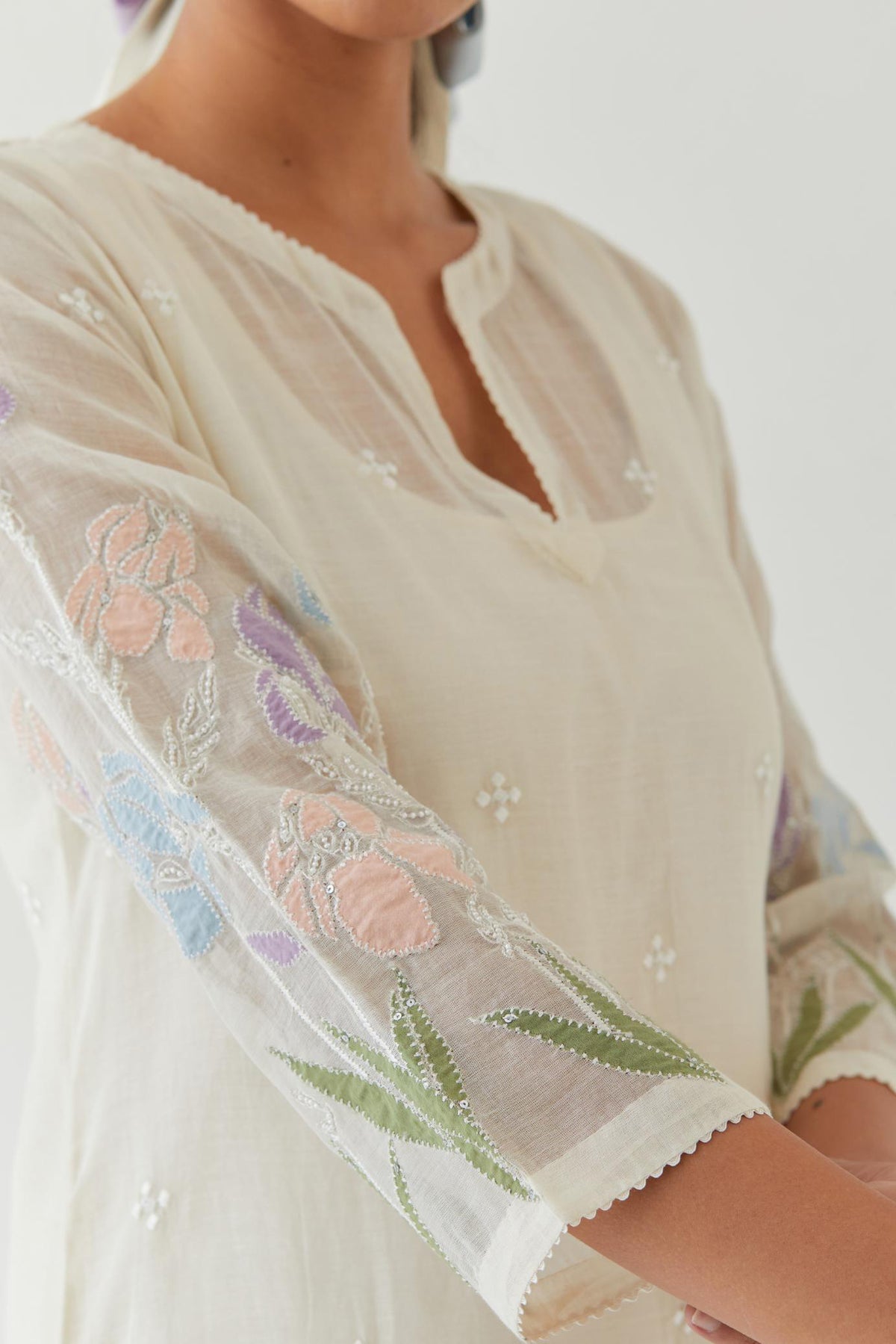 Off white cotton chanderi straight kurta set, decorated with appliqué at the hem and sleeves.