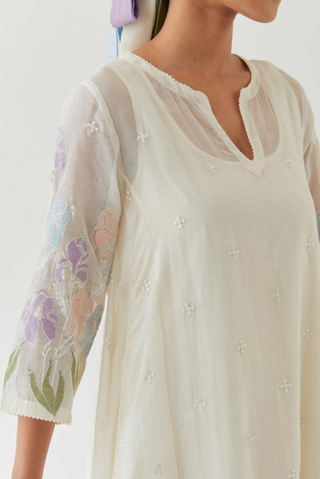 Off white cotton chanderi easy fit, asymmetric hem, paneled kurta set with applique work at hem and sleeves.