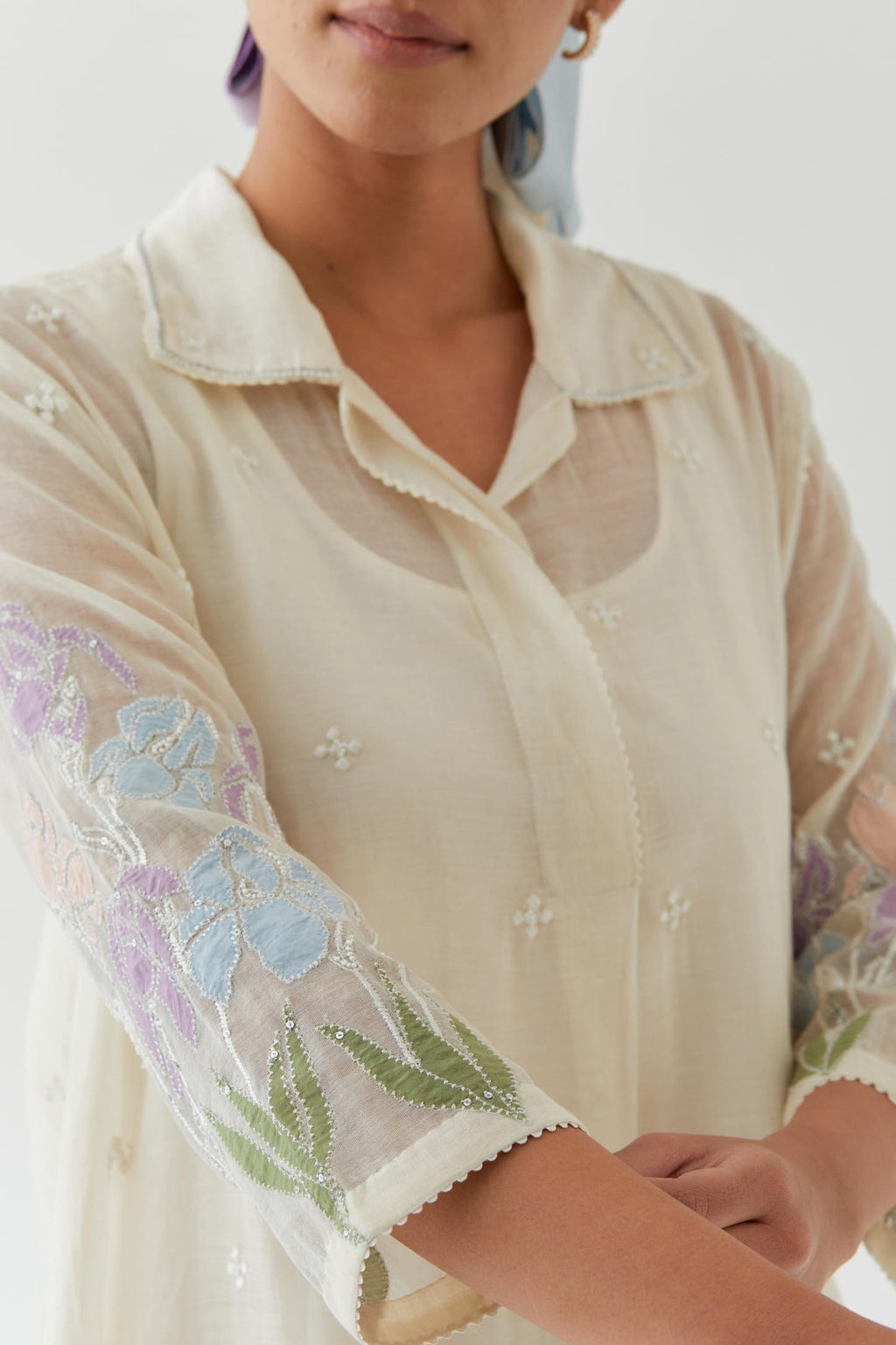 Off white cotton chanderi A-line short kurta set with applique work at hem, highlighted with bead & sequins work.