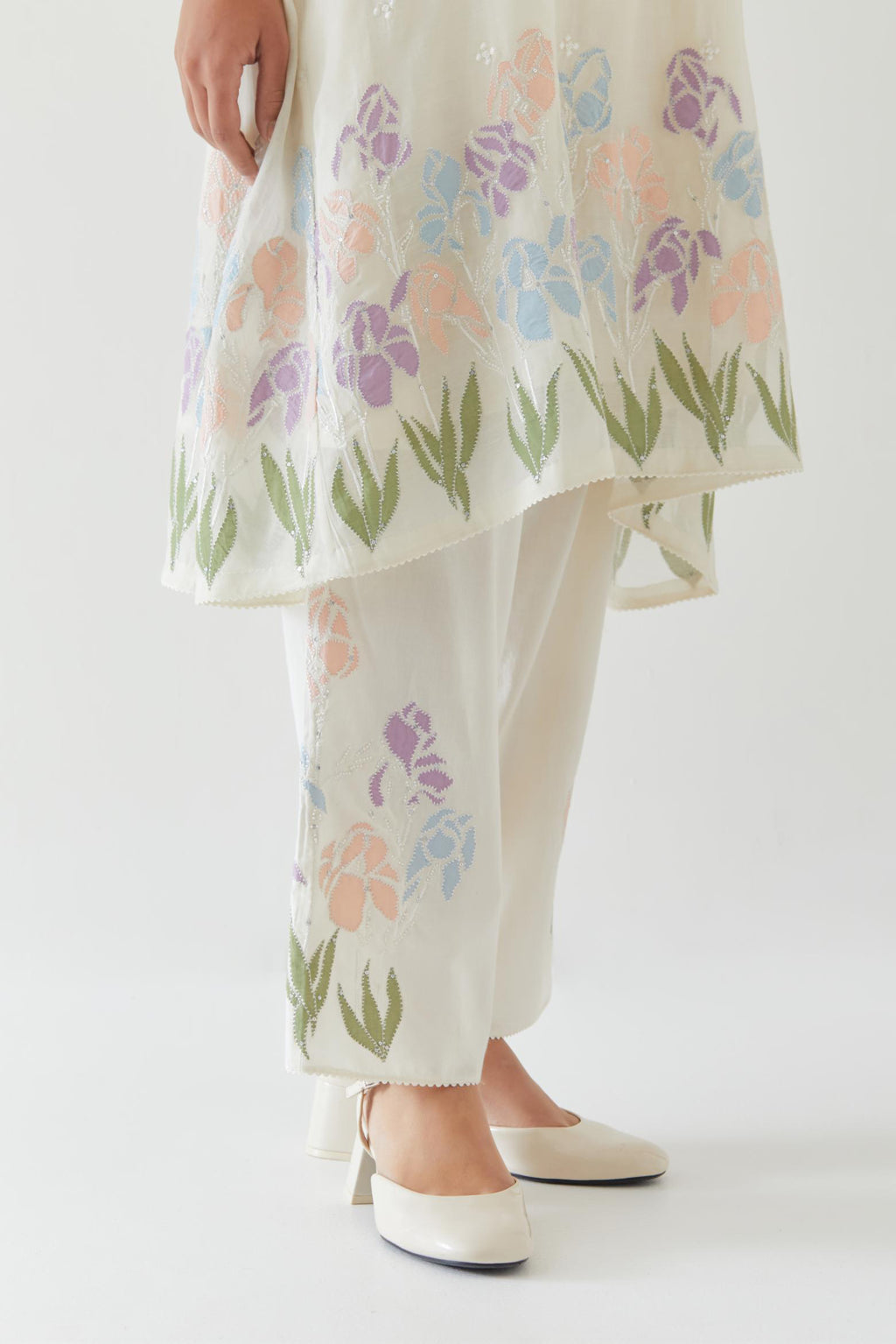 Off white cotton chanderi A-line short kurta set with applique work at hem, highlighted with bead & sequins work.