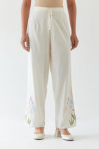 Off white cotton straight pants detailed with multi colored applique, highlighted with bead & sequins work.