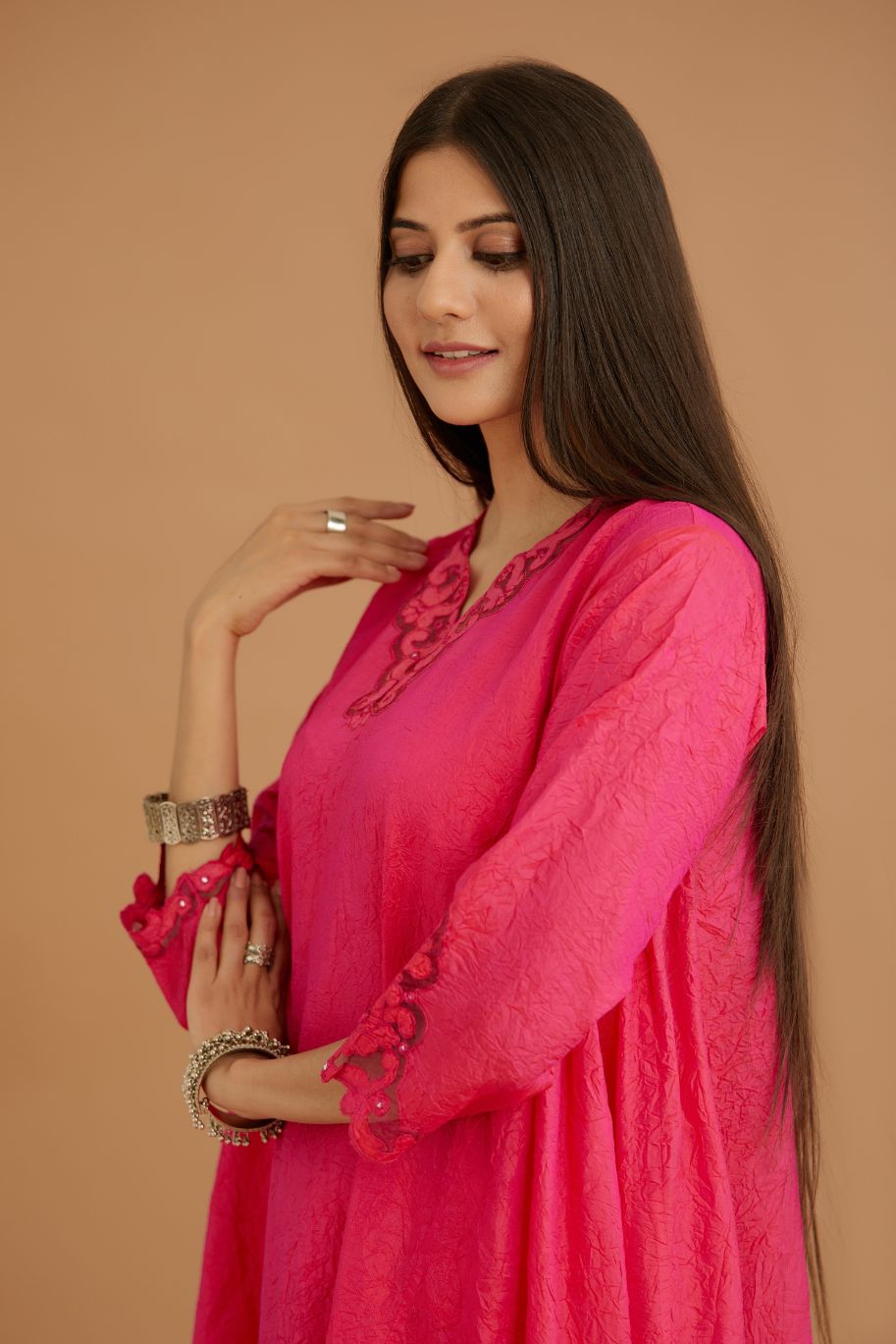 Fuchsia hand crushed silk kurta with cutwork embroidered asymmetric hem, highlighted with hand attached mirrors.