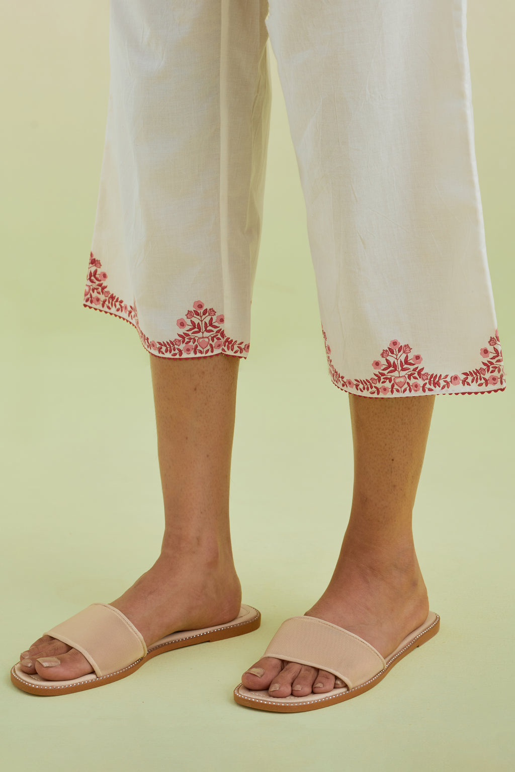 Off white straight ankle length pants with pink colored hand-block printed border at hem.