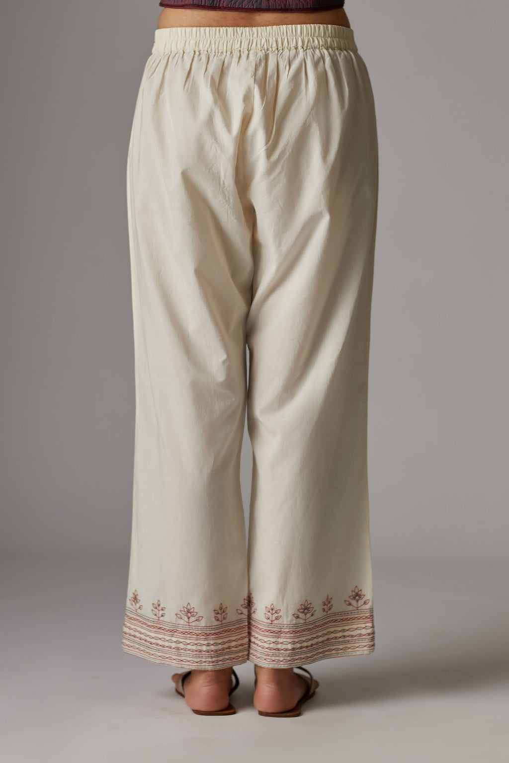 Off white straight pants with quilted embroidered hem