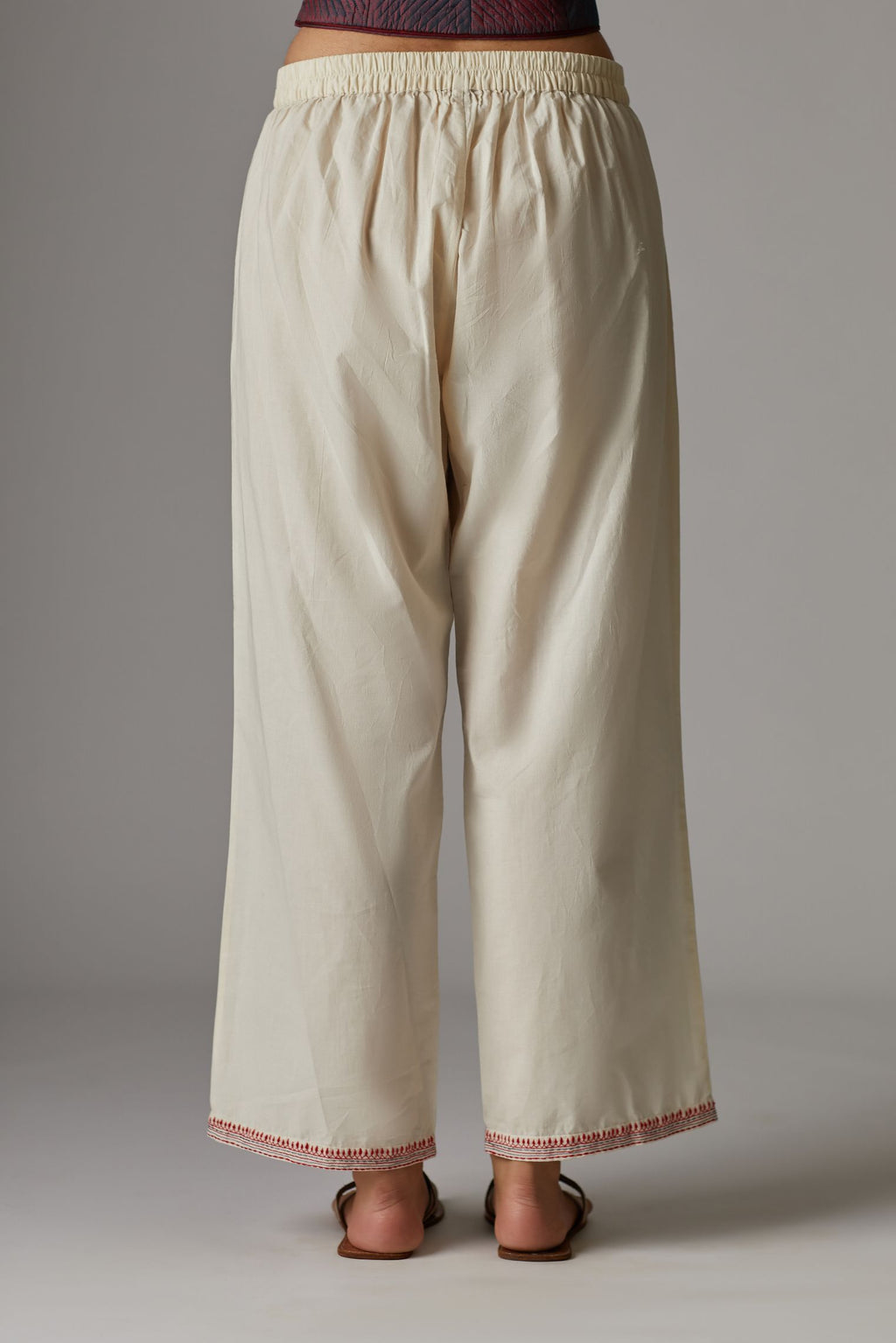 Off white straight pants with contrast thread embroidered hem
