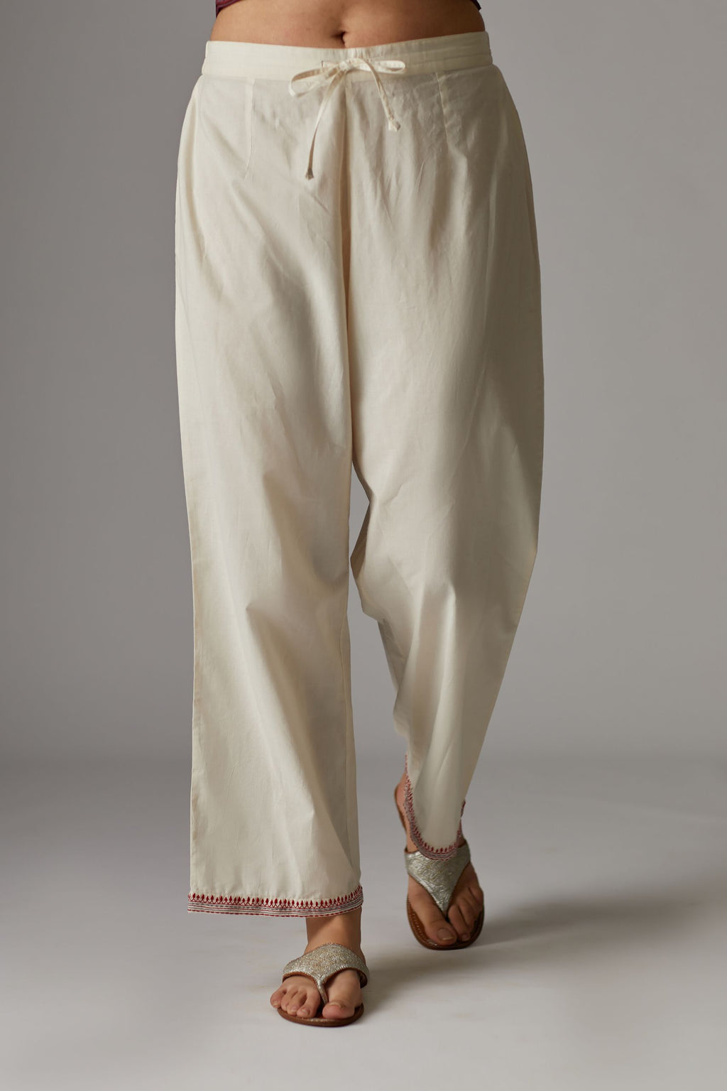 Off white straight pants with contrast thread embroidered hem