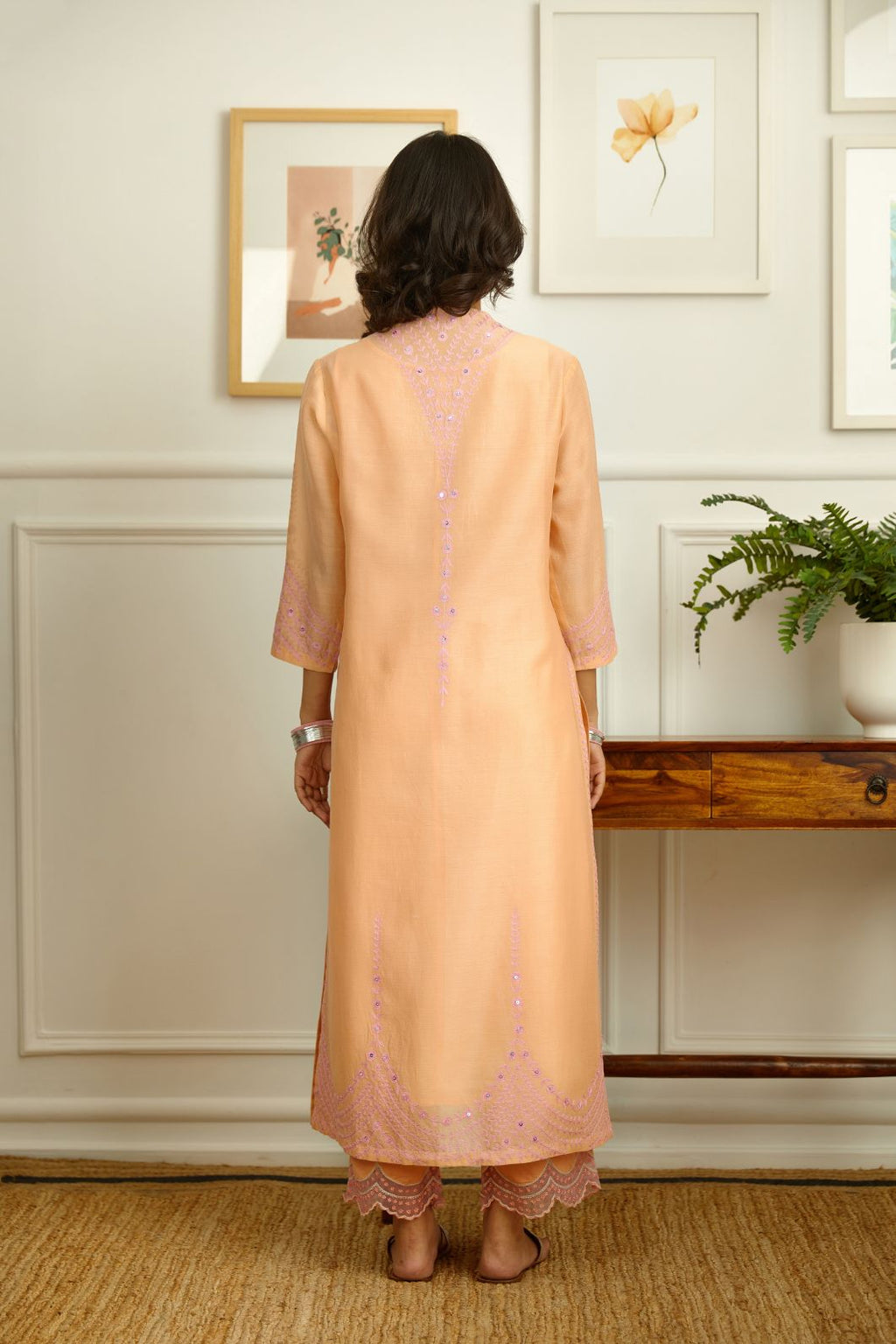 Straight kurta set with pink thread embroidery and raised ‘V’ neckline.