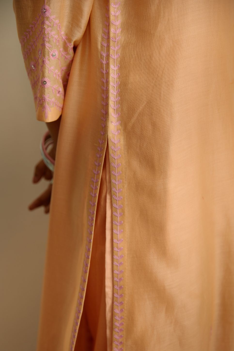 Straight kurta set with pink thread embroidery and raised ‘V’ neckline.
