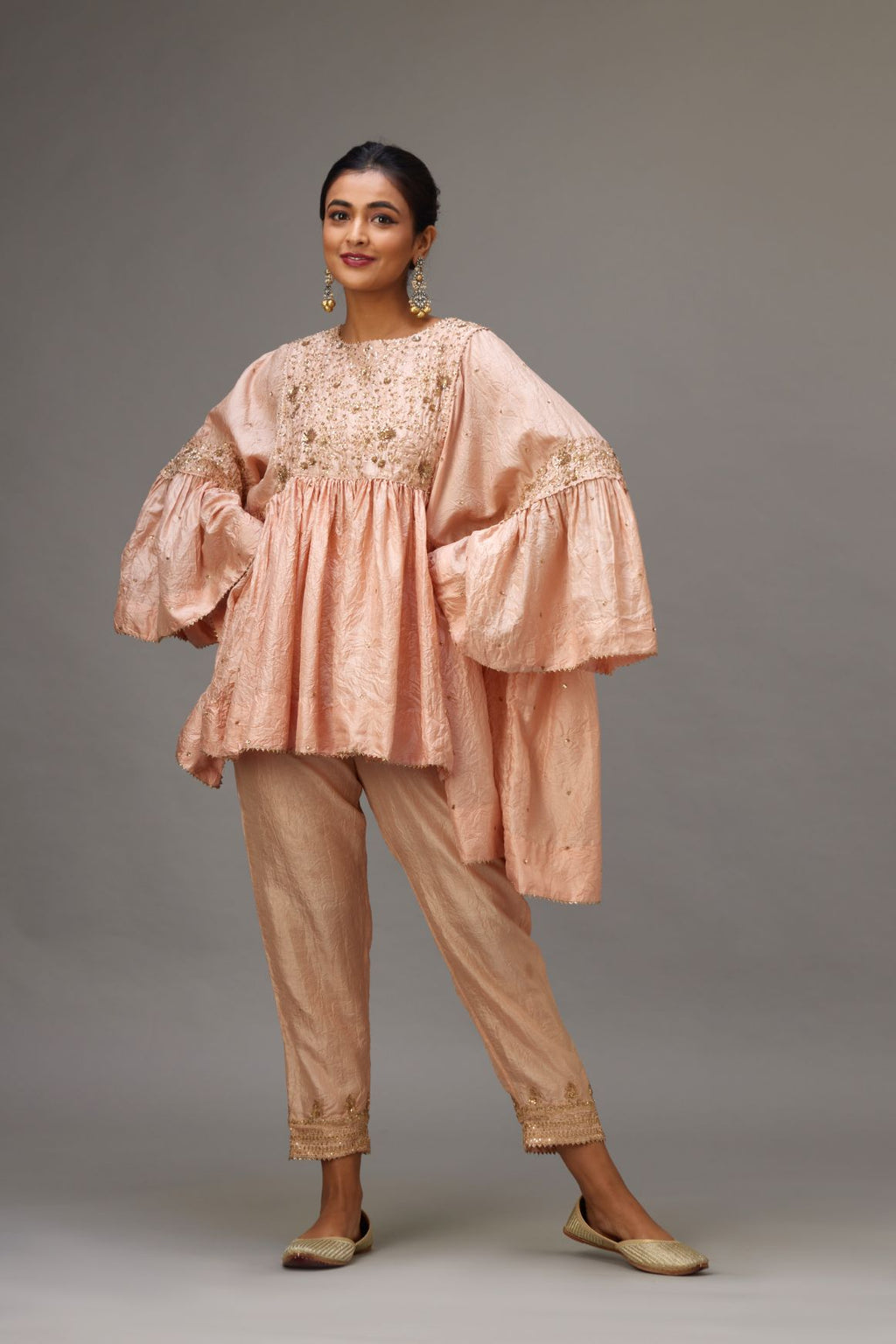 Pink solid easy fit top with golden sequins work at front and back yoke, paired with pink hand crushed silk pants with embroidered sequins border at hem.