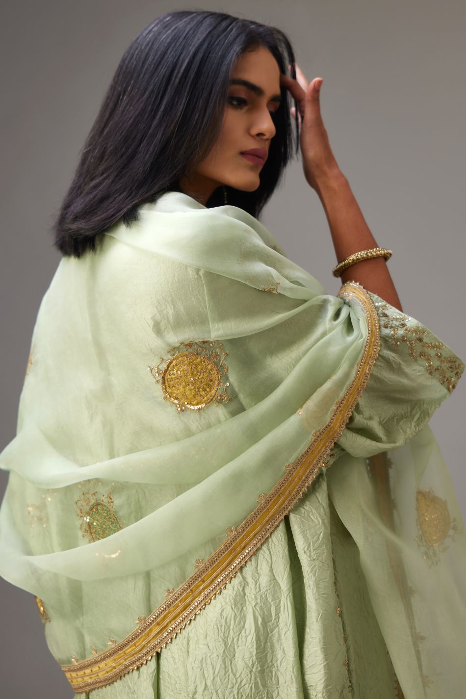 Green silk organza dupatta highlighted with all-over embroidered boota and contrast colored border running along all edges.