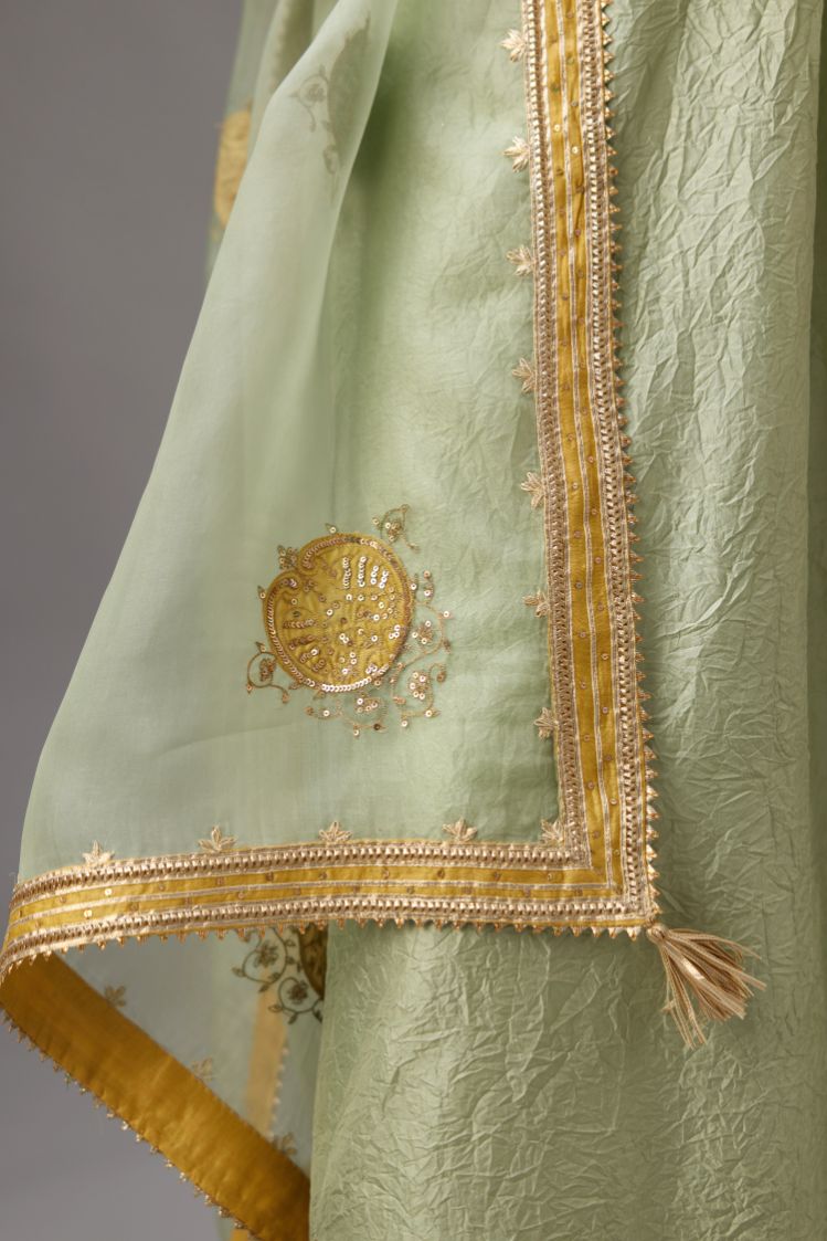 Green silk organza dupatta highlighted with all-over embroidered boota and contrast colored border running along all edges.