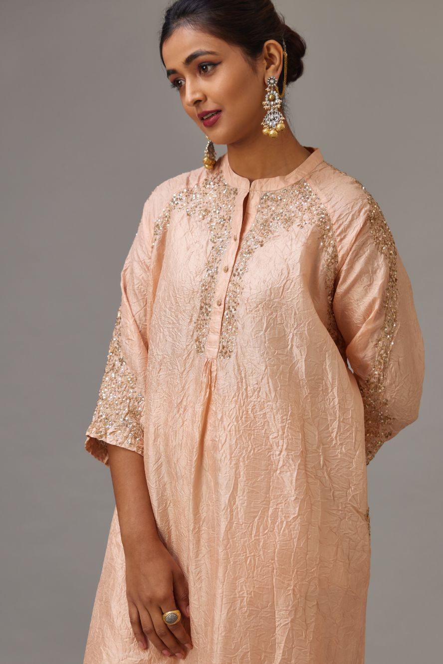 Pink silk hand crushed kurta set with button placket neckline, highlighted with gold sequins work at hem, neck and armhole.