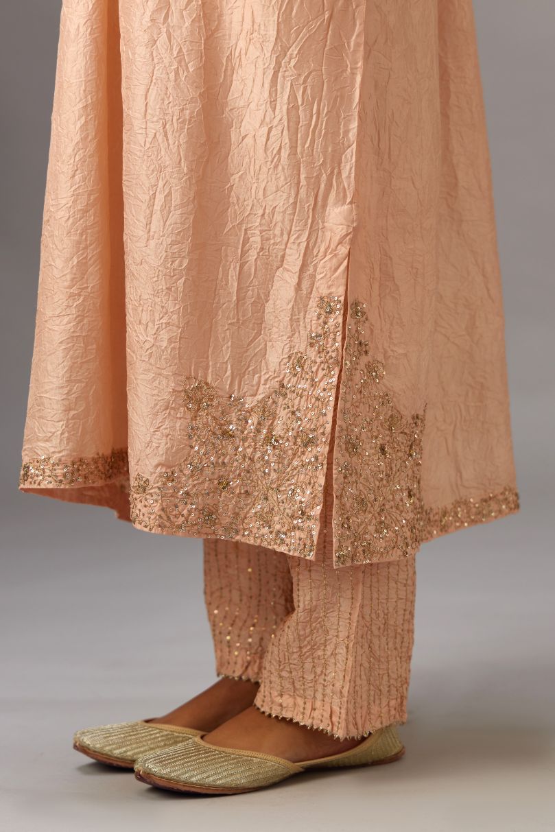 Pink silk hand crushed kurta set with button placket neckline, highlighted with gold sequins work at hem, neck and armhole.