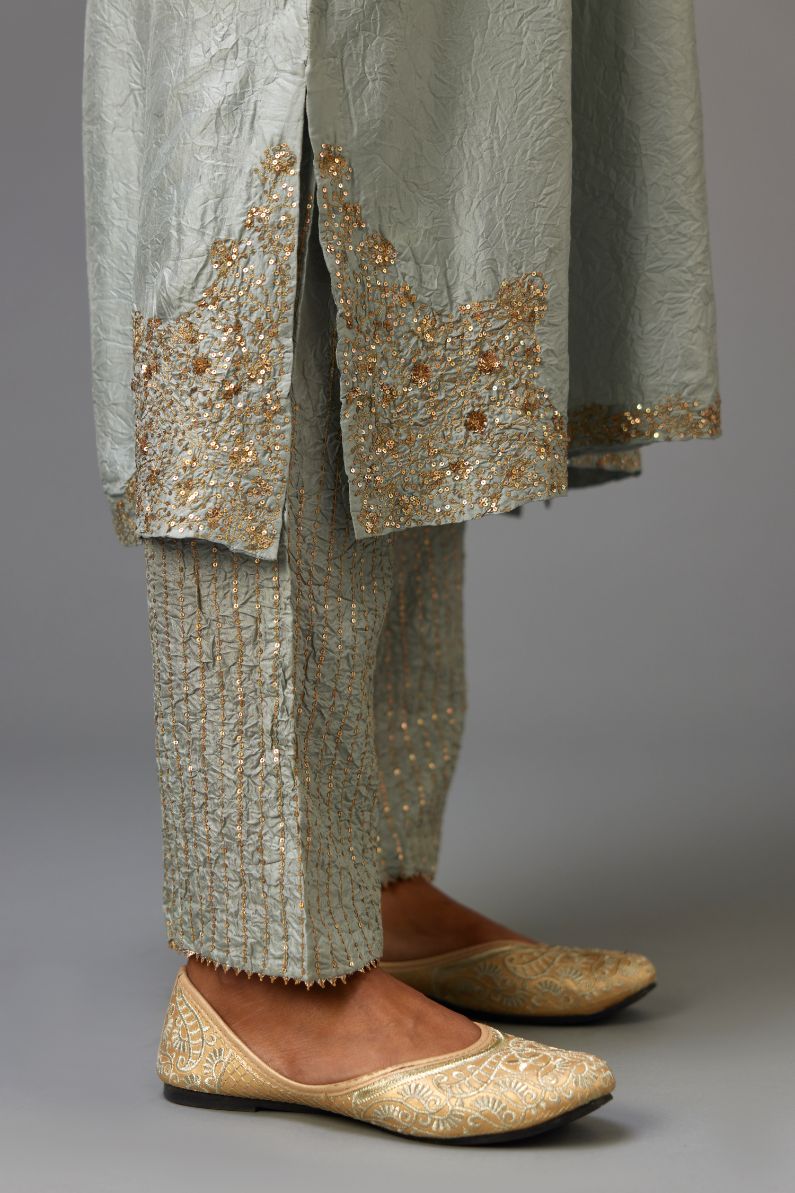 Blue silk hand crushed kurta set with button placket neckline, highlighted with gold sequins work at hem, neck and armhole.