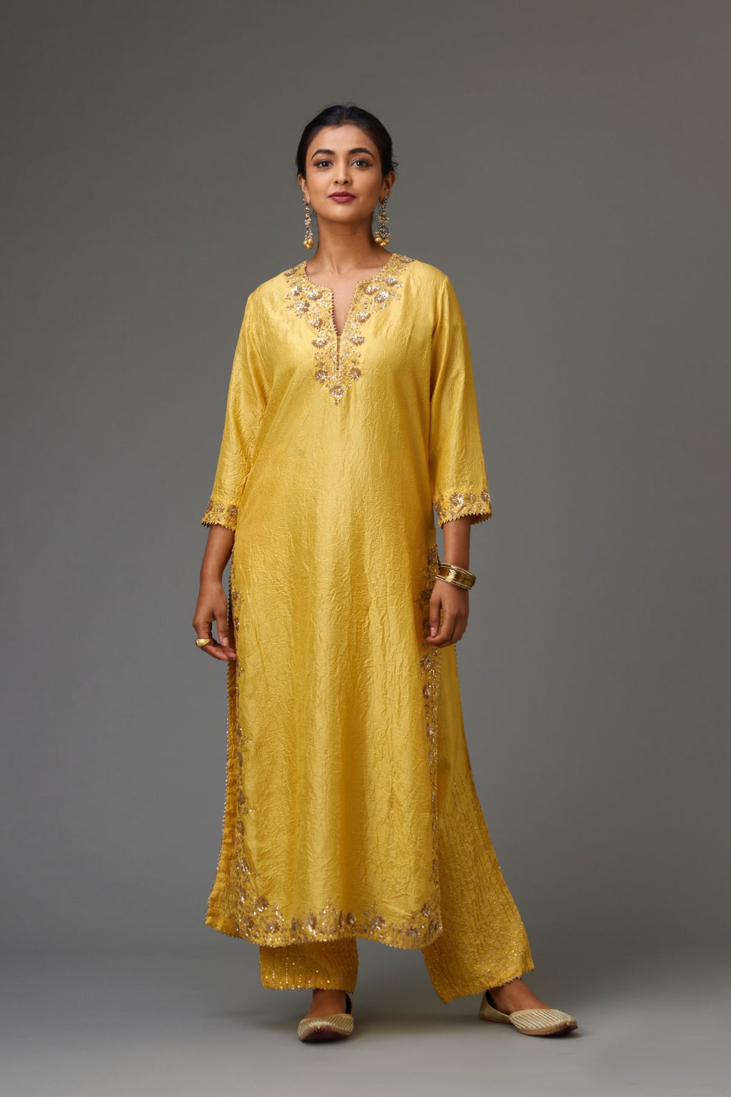 Yellow hand crushed silk straight kurta set highlighted with gold sequins and zari handwork.