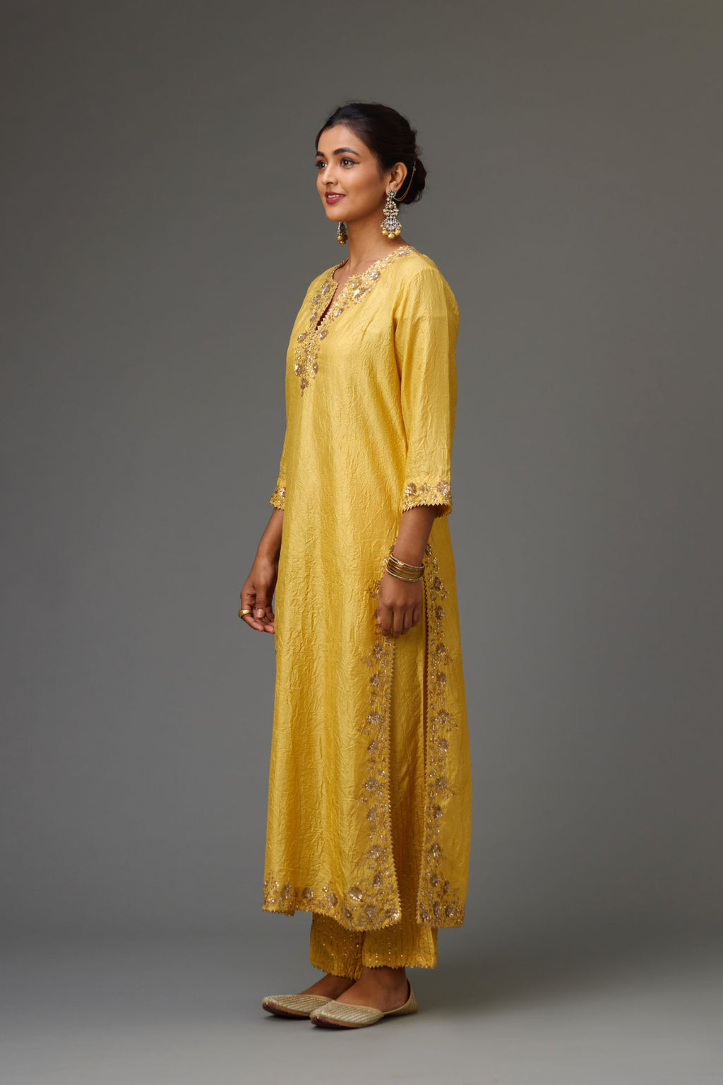 Yellow hand crushed silk straight kurta set highlighted with gold sequins and zari handwork.