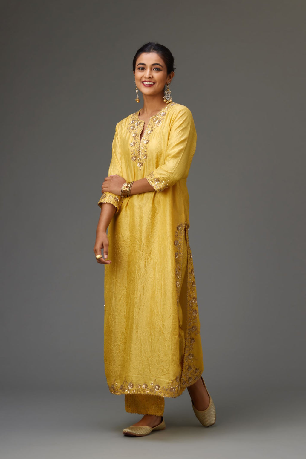 Yellow hand crushed silk straight kurta set highlighted with gold sequins and zari handwork.